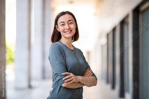 attractive older woman smiling with arms crossed