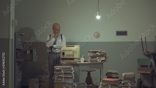 Businessman searching for files in a messy office