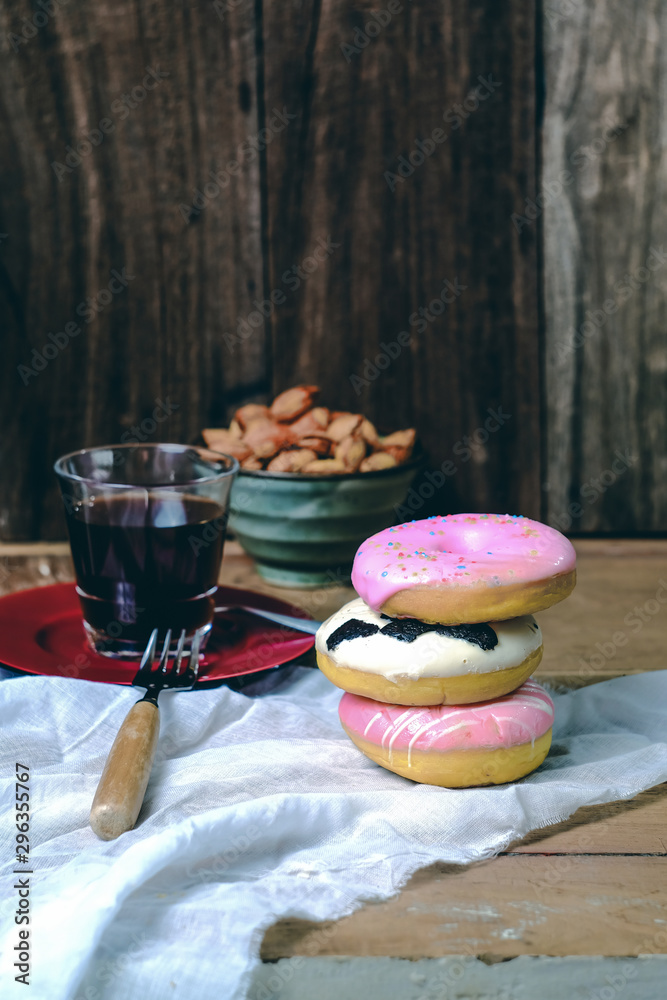 Delicious colorful donuts food on wooden background.