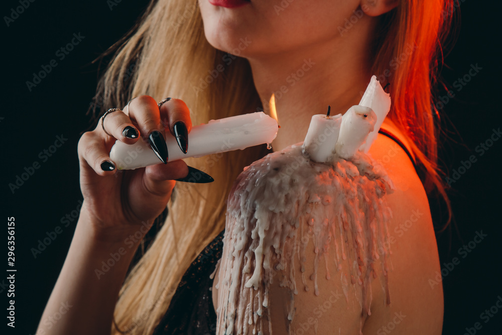 Foto Stock a girl with long hair in the image of a witch is trying to set herself on fire. rituals with candles for love spell and damage. expulsion of a bad Foto Stock a girl with long hair in the image of a witch is trying to set herself on fire. rituals with candles for love spell and damage. expulsion of a bad