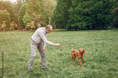 Hundsome man in a park. Adult male with cute dog