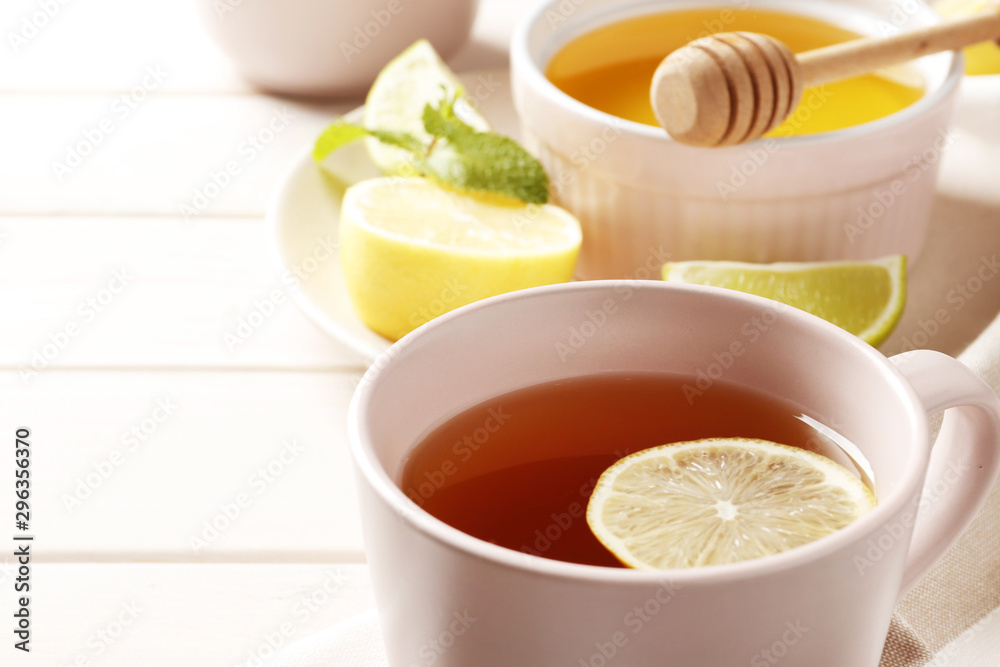 cup of hot tea with ginger, lemon and mint on a white wooden background cup of hot tea with ginger, lemon and mint on a white wooden background
