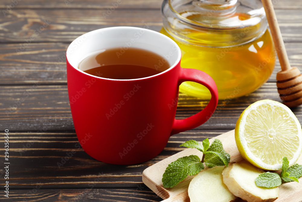 cup of hot tea with honey, ginger, lemon and mint on a wooden background cup of hot tea with honey, ginger, lemon and mint on a wooden background