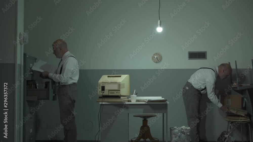 Multitasking office worker searching for files in his office