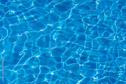 Water ripples on blue tiled swimming pool background. Top view