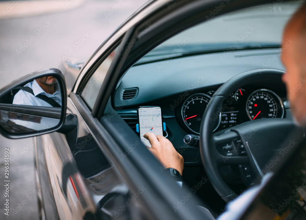 Businessman driving vehicle and using smartphone Businessman driving vehicle and using smartphone