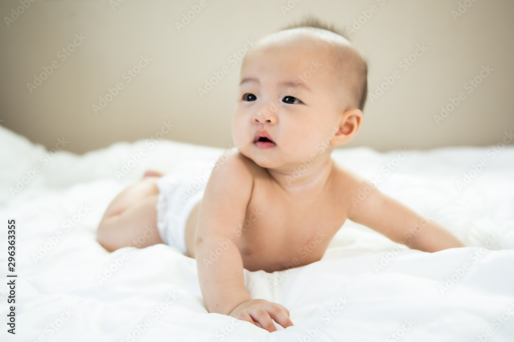 Asian baby happy in the room.Asian baby girl lying down on bed . Asian baby happy in the room.Asian baby girl lying down on bed .