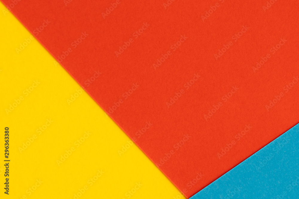 Yelllow blue red color paper background. Geometric figures, shapes. Abstract geometric flat composition. Empty space on monochrome cardboard. Yelllow blue red color paper background. Geometric figures, shapes. Abstract geometric flat composition. Empty space on monochrome cardboard.