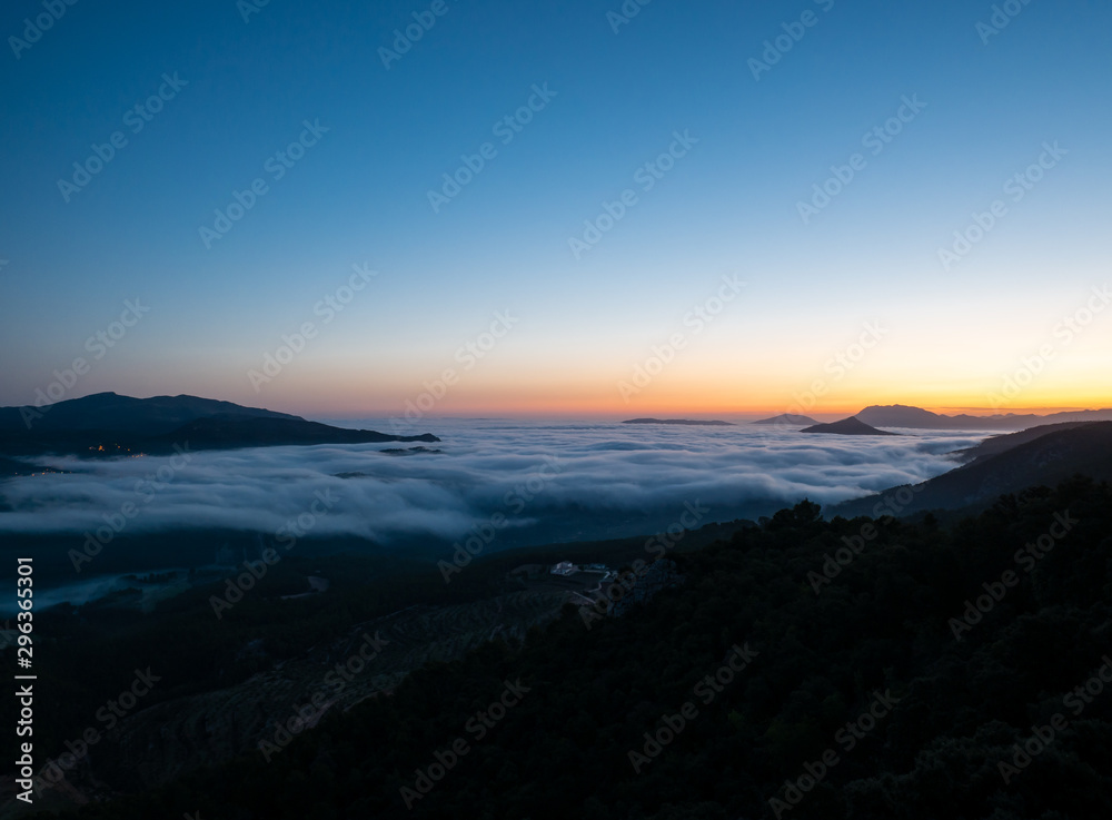  sunrise with low clouds and mountains silhouettes