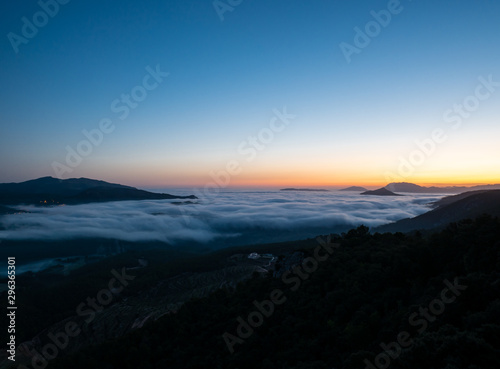  sunrise with low clouds and mountains silhouettes © Miguel Fernandez