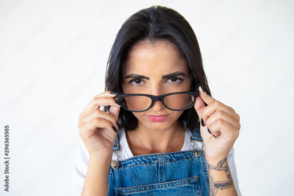 Closeup shot of beautiful serious young woman in eyeglasses. Closeup shot of beautiful young woman in eyeglasses looking at camera. Female beauty concept Closeup shot of beautiful serious young woman in eyeglasses. Closeup shot of beautiful young woman in eyeglasses looking at camera. Female beauty concept