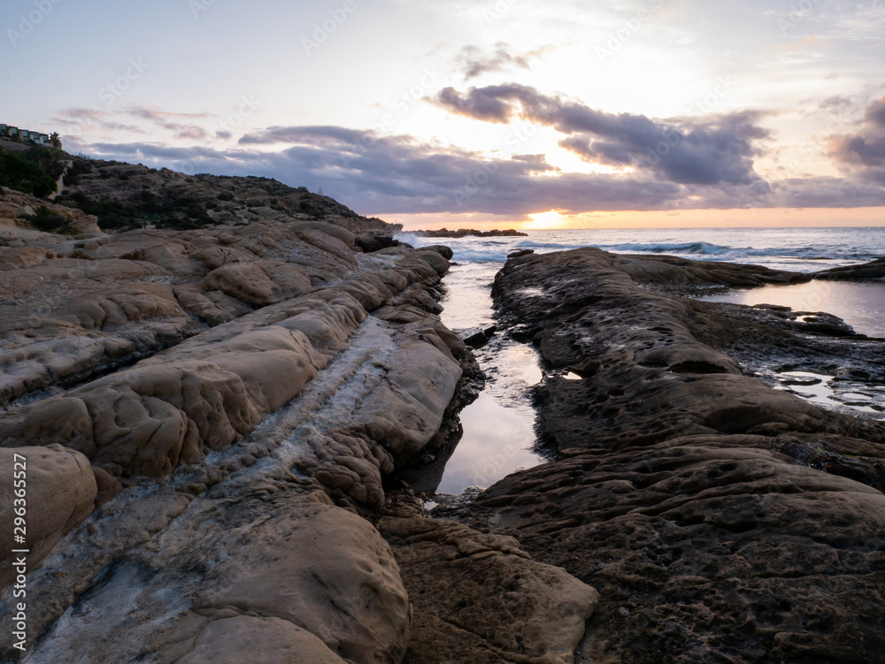Fototapeta premium sunrise on rocky beach with orange light