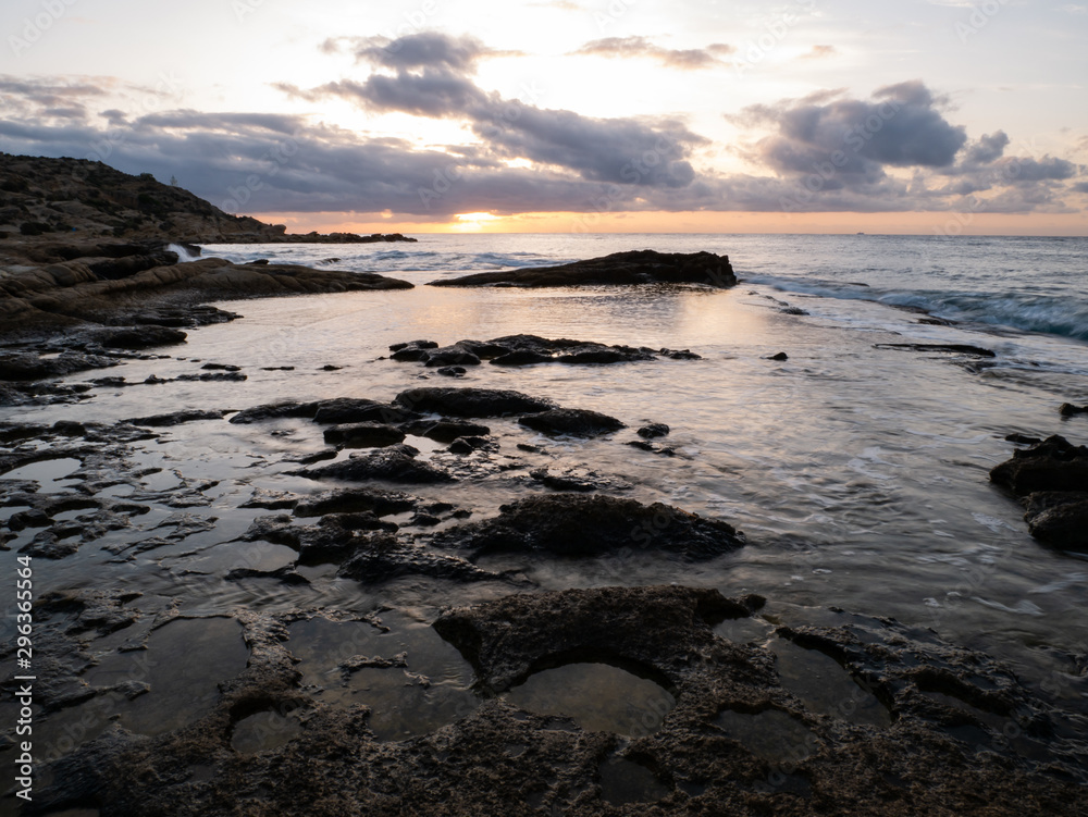 sunrise on rocky beach with orange light sunrise on rocky beach with orange light
