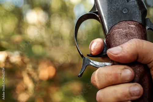 Finger on the trigger of a hunting rifle in the autumn forest close-up. The hunting period, the fall season is open, the search for prey.