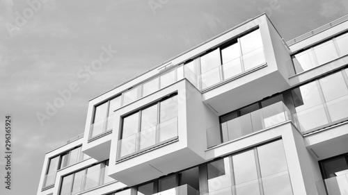 Fragment elewacji budynku z oknami i balkonami. Nowoczesny dom z wieloma mieszkaniami. Czarny i biały.
