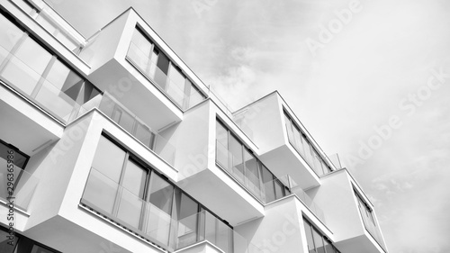 Fragment elewacji budynku z oknami i balkonami. Nowoczesny dom z wieloma mieszkaniami. Czarny i biały.