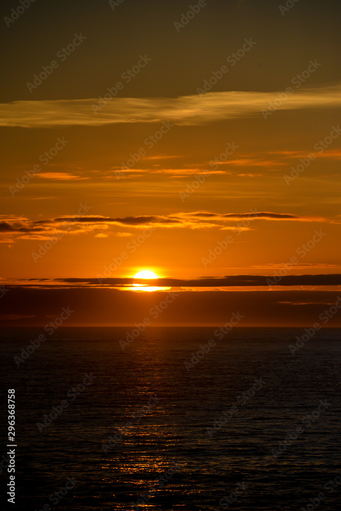 Obraz premium SSunset over the ocean viewed from a cruise ship a beautiful golden glow.