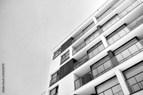 Fragment of a facade of a building with windows and balconies. Modern home with many flats. Black and white. © Grand Warszawski