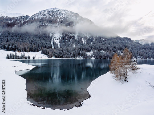 Clouds around snow capped mountain and lake photo