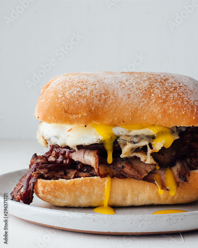 Close up view of beef brisket sandwich with eggs and ciabatta roll