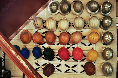 Variety of hardhats hanging on wall photo