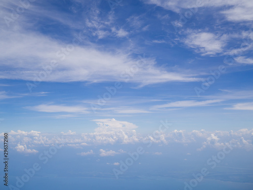 Clouds from airplane window with blue sky and high angle ground © Lucky7Trader