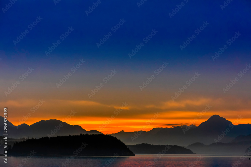 Orange Sunset over Silhouetted Mountains, Ocean