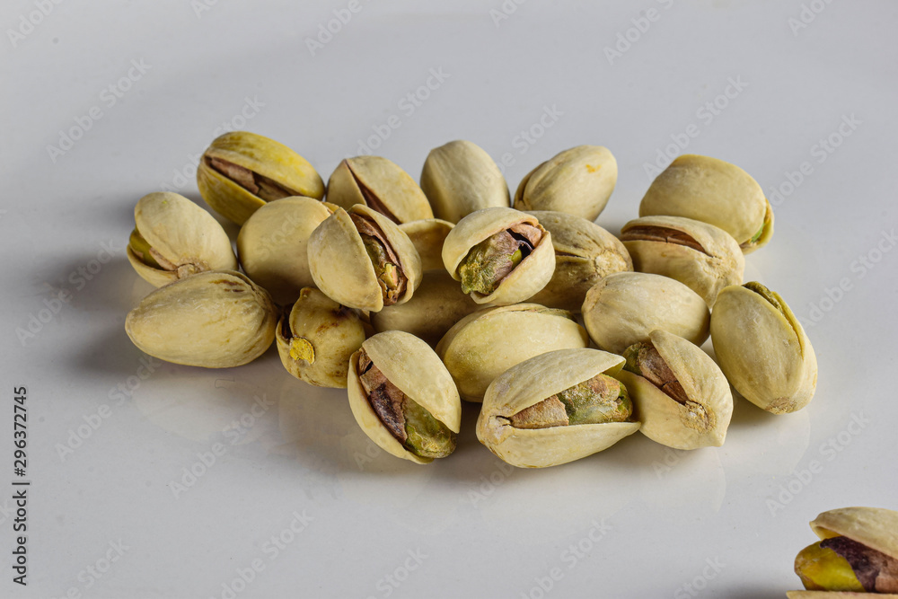 several pistachios on a white back ground several pistachios on a white back ground