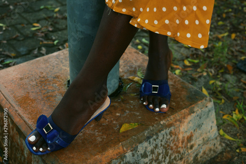 Low section of woman wearing sandals standing outdoors photo