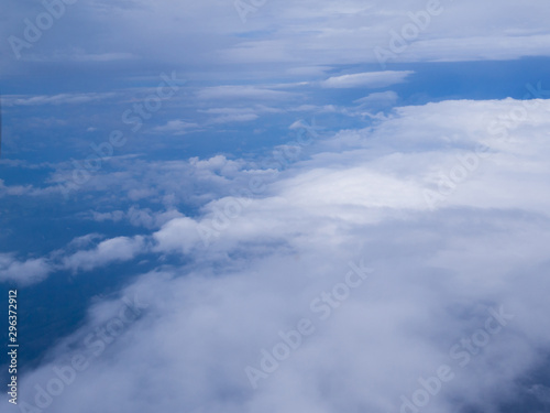 Clouds from airplane window with blue sky