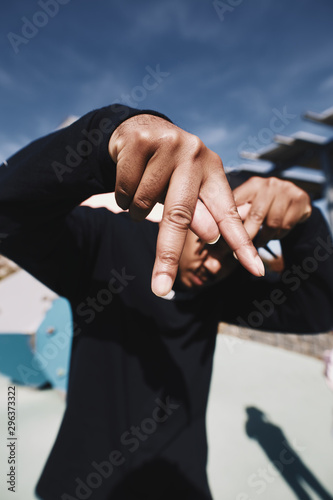 Portrait of man displaying inverted victory symbol