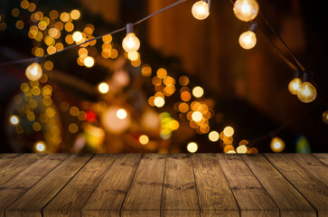 Image of wooden table in front of abstract blurred restaurant lights background