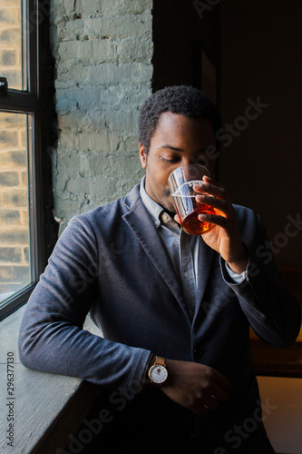 Stylish young man drinking cocktail photo