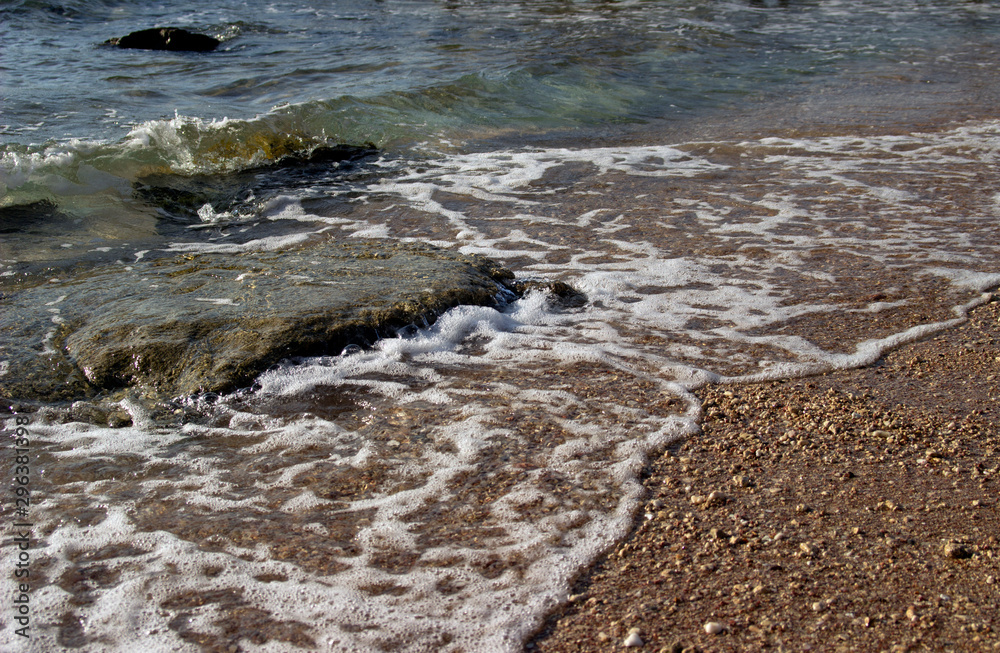 Summer background of hot sand with sea or ocean wave bubbles with copy space for card or advertisement at dawn or sunset Summer background of hot sand with sea or ocean wave bubbles with copy space for card or advertisement at dawn or sunset