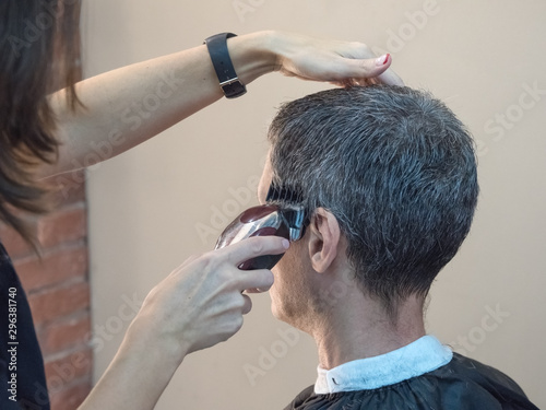 Man in barber chair, hairdresser haircut his hair. Barber shop. 