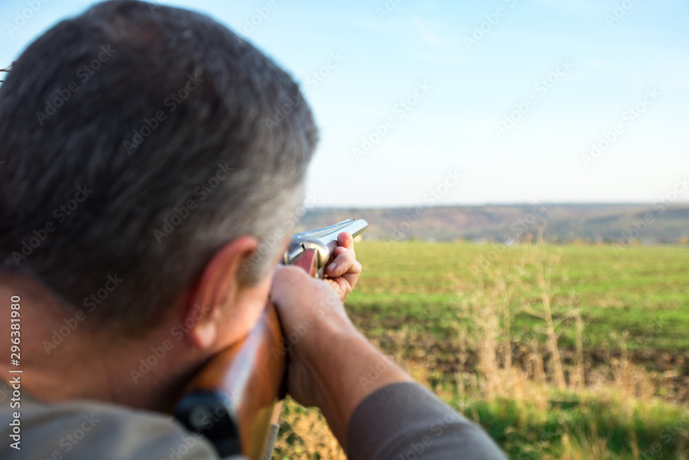 Fototapeta premium male with double barreled shotgun is taking aim