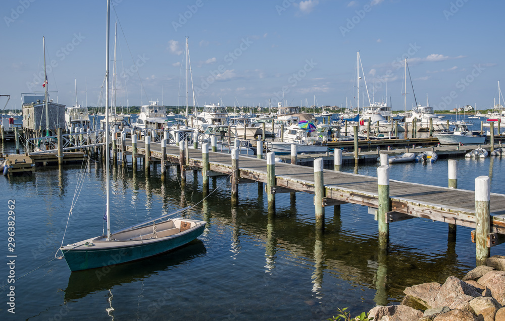 Small Sailboat at a New England Wharf:  A small boat sits moored to a wooden pier on a calm summer evening in Rhode Island.