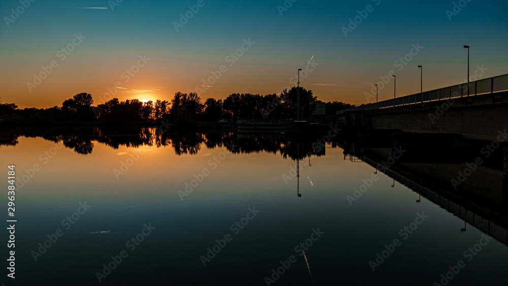 Fototapeta premium Beautiful sunset with reflections in the river Isar near Plattling, Bavaria, Germany