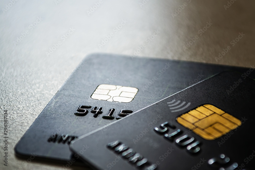 Two black credit cards with chips and contactless pay technology close-up. Low key shot with old credit cards. Two black credit cards with chips and contactless pay technology close-up. Low key shot with old credit cards.