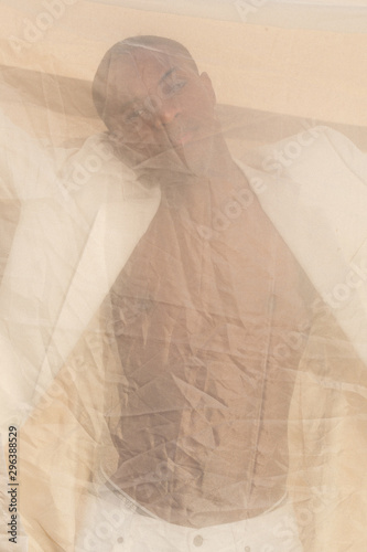Portrait of model looking through sheer fabric