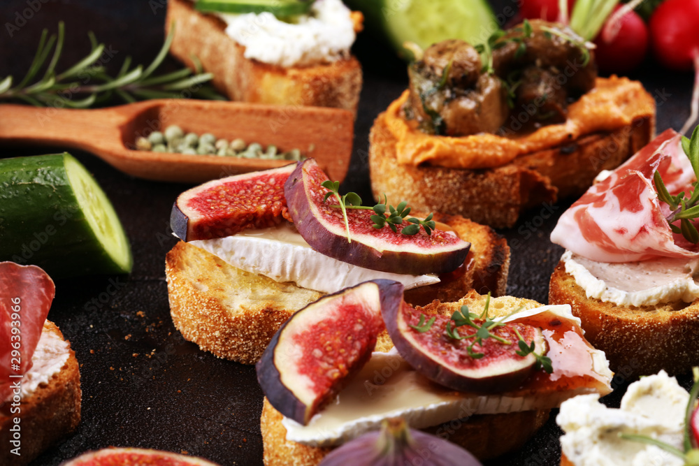 Assorted bruschetta with various toppings. Appetizing bruschetta or brie crostini. Variety of small sandwiches. Mix bruschetta on table Assorted bruschetta with various toppings. Appetizing bruschetta or brie crostini. Variety of small sandwiches. Mix bruschetta on table
