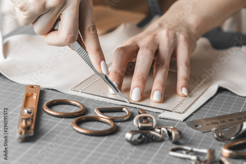 Woman measuring and cutting leather in a workshop photo