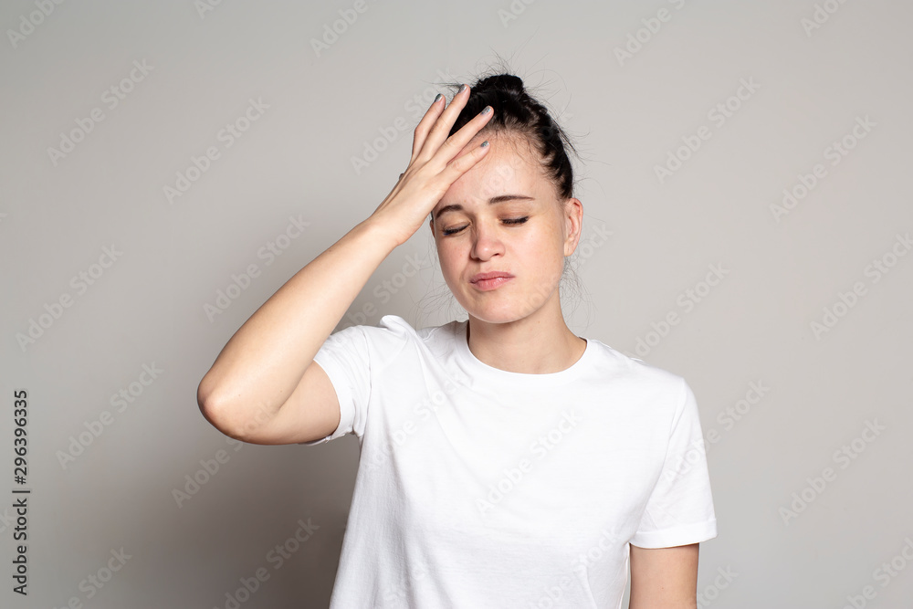 Young woman suffering from a headache. She closed her eyes and holds his hand on his head. Health concept. Young woman suffering from a headache. She closed her eyes and holds his hand on his head. Health concept.