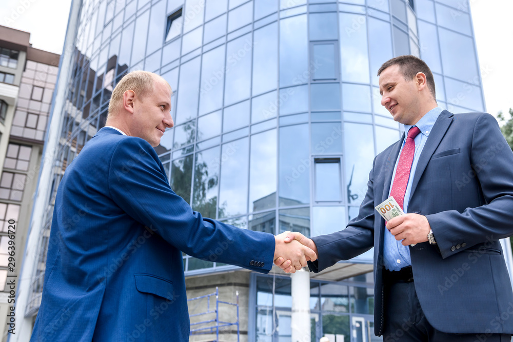 Two serious businessman posing against business center Two serious businessman posing against business center