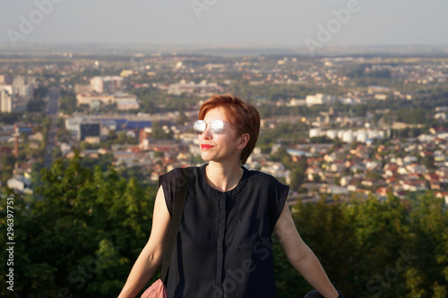 Young short hairstyle caucasian woman enjoying sunset from hill and smiling