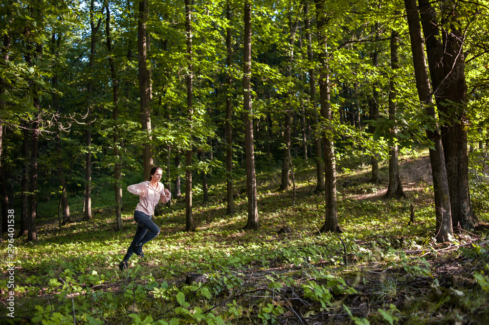 Young girl jogging in the woods on a sunny morning. Young girl jogging in the woods on a sunny morning.