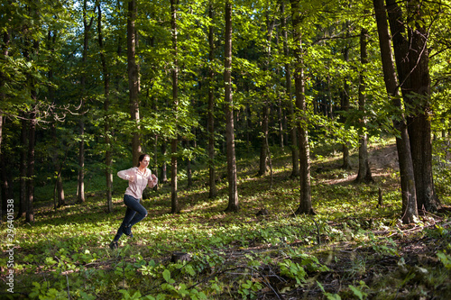 Young girl jogging in the woods on a sunny morning. © xpabli
