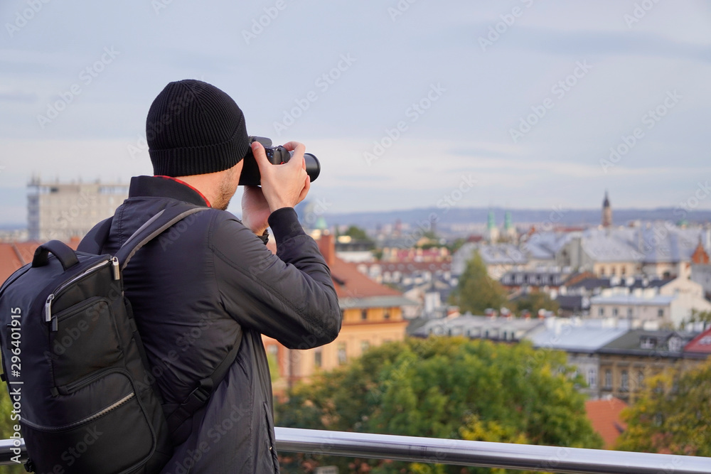 silhouette of a man with a camera on the background of the city. tourist, autumn photo tours of the cities. photo from the roof in Krakow. top view