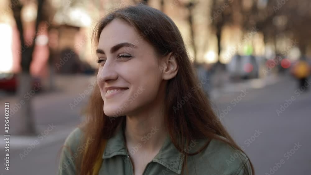 Close-up portrait of happy European woman student laughing cheerful looking at camera in the city enjoying lifestyle, urban background Close-up portrait of happy European woman student laughing cheerful looking at camera in the city enjoying lifestyle, urban background