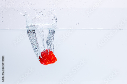 Fresh strawberry falling in water splash isolated on white background	